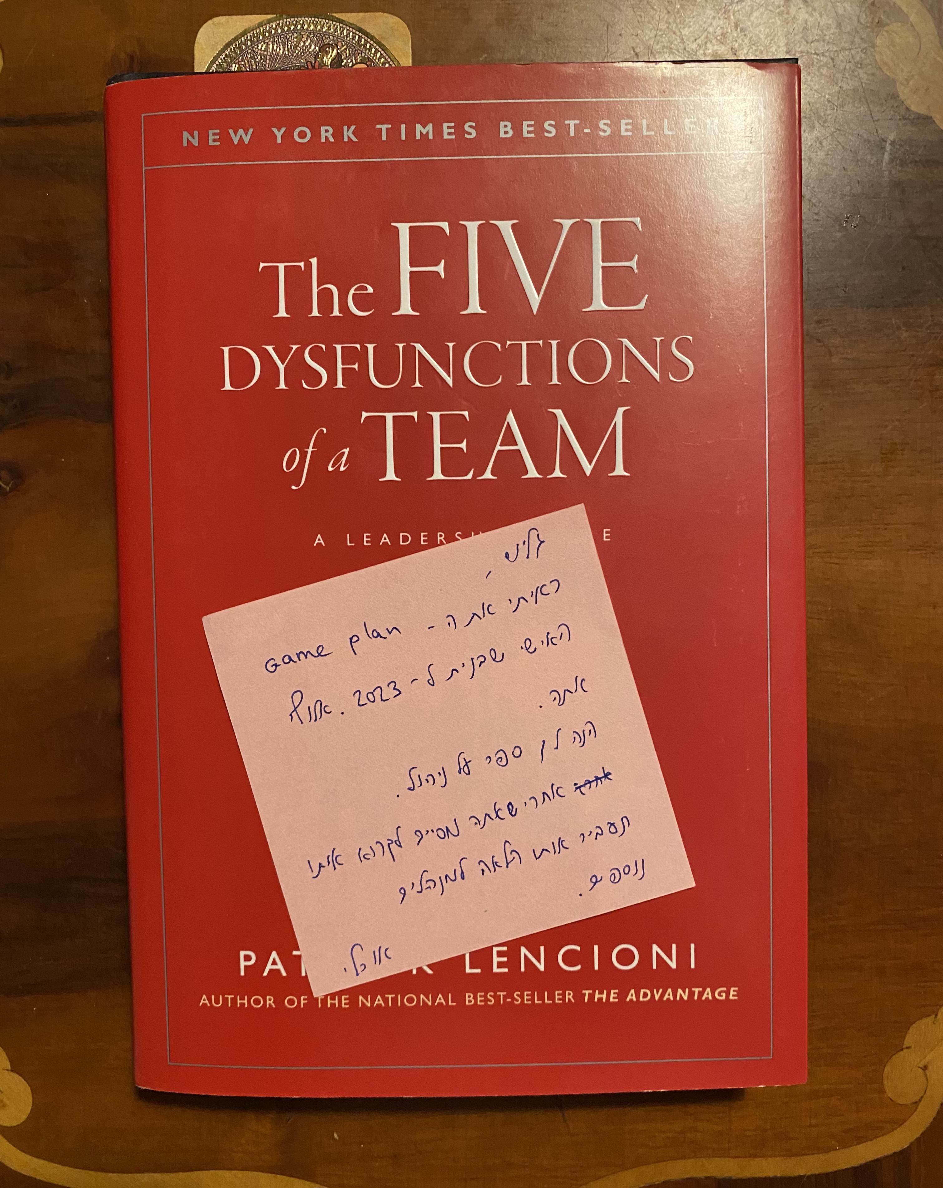 "The Five Dysfunction of a Team" book cover with a personal note